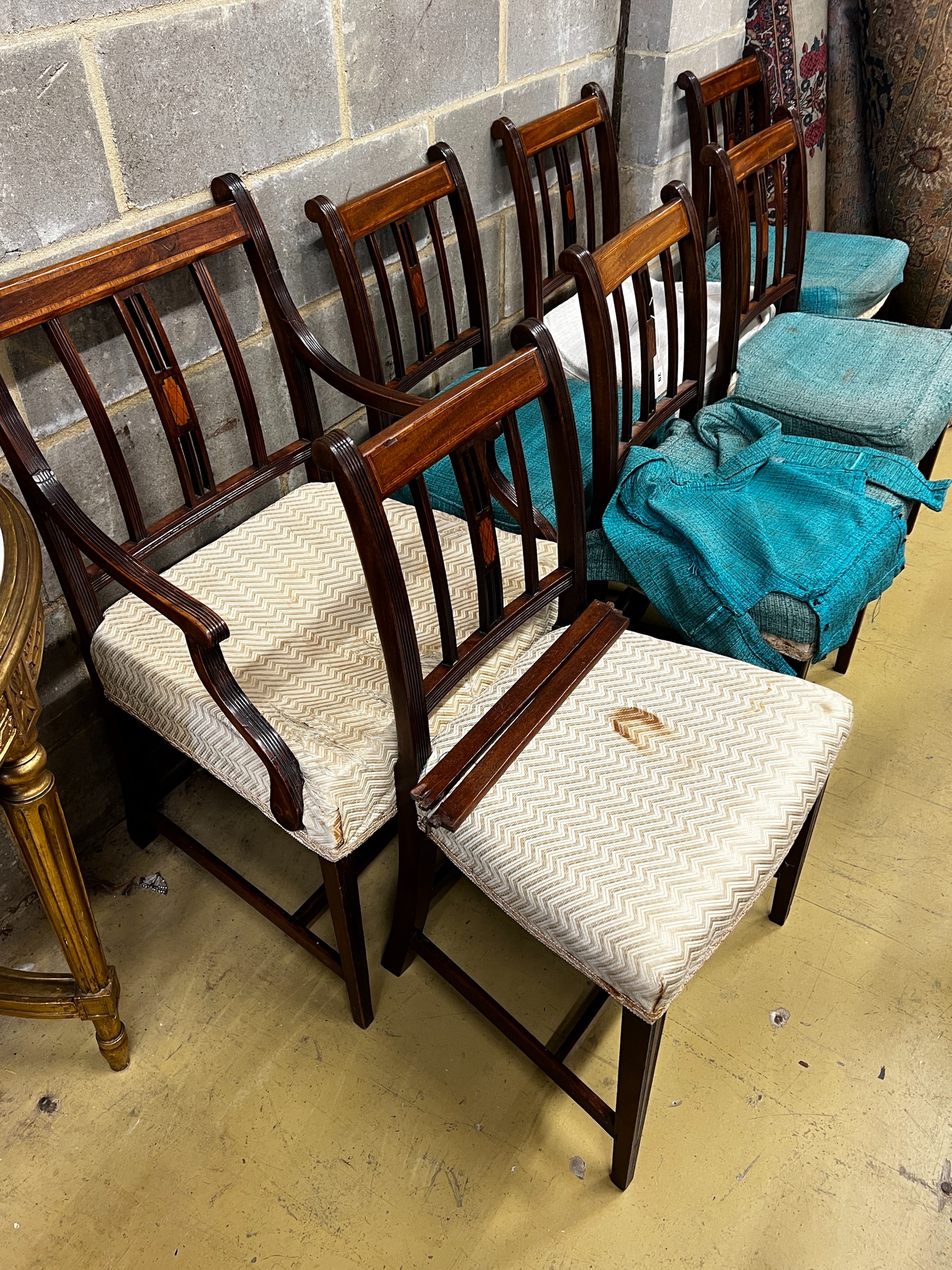 A set of seven George III inlaid mahogany dining chairs, one with arms